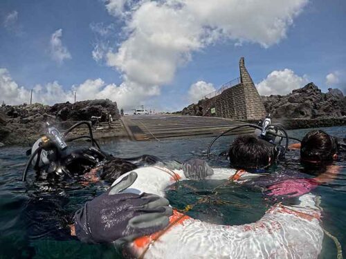 穏やかな湾内で浮き輪に掴まり色々練習していって