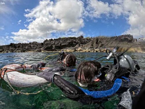 手前の方で浮き輪に掴まり海に慣れ